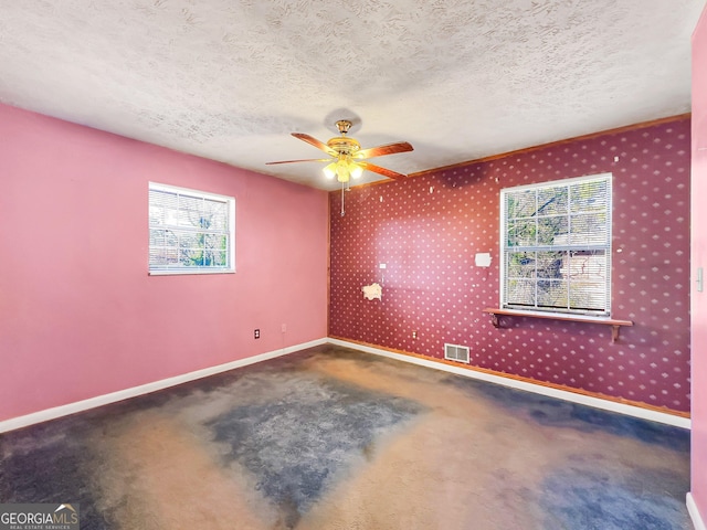 spare room with ceiling fan, plenty of natural light, and a textured ceiling