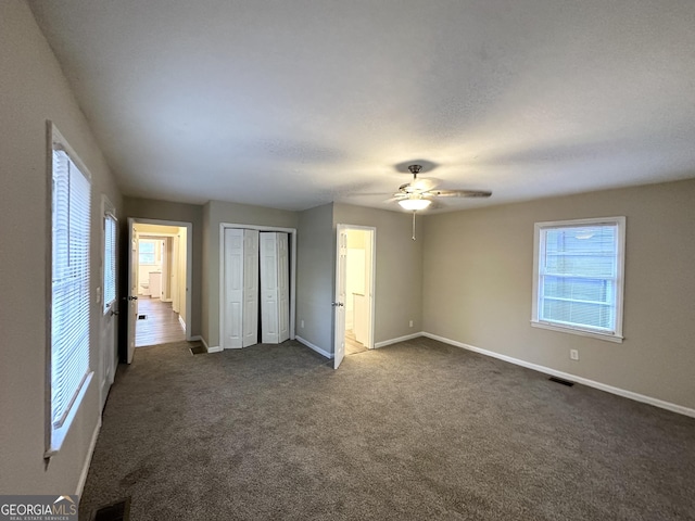 unfurnished bedroom featuring ceiling fan and dark colored carpet