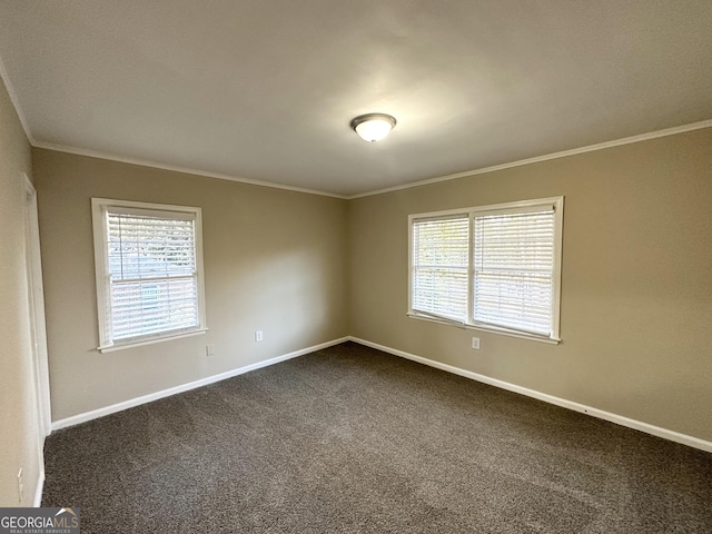 empty room with dark carpet, plenty of natural light, and ornamental molding