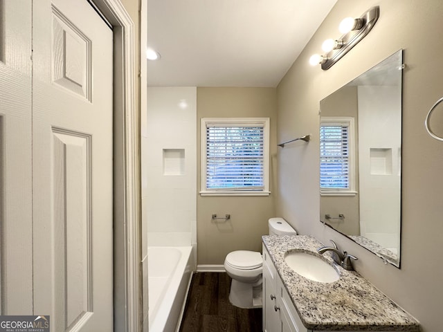 bathroom featuring a healthy amount of sunlight, vanity, toilet, and hardwood / wood-style floors