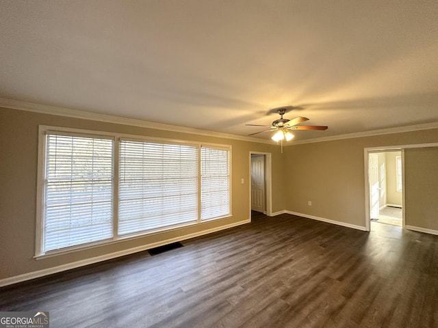 empty room with crown molding, dark wood-type flooring, and ceiling fan