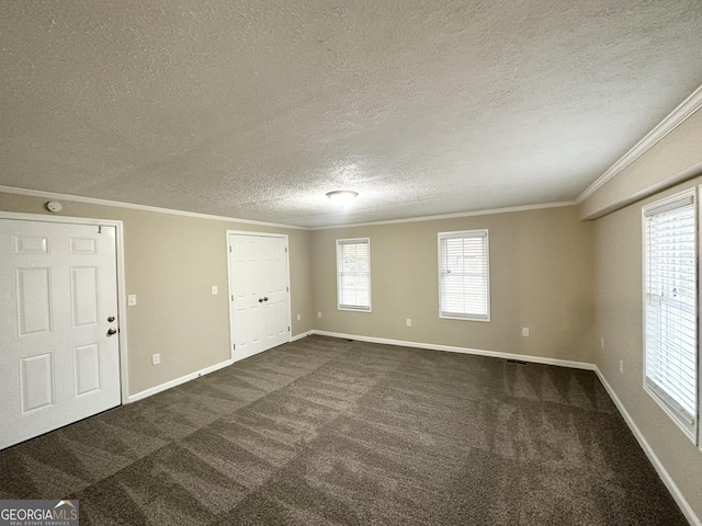 spare room with crown molding, dark carpet, and a textured ceiling