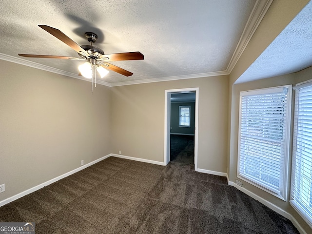 spare room with ceiling fan, ornamental molding, dark carpet, and a textured ceiling