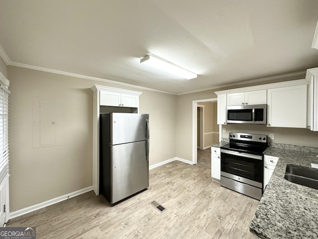 kitchen featuring sink, appliances with stainless steel finishes, light stone counters, ornamental molding, and white cabinets