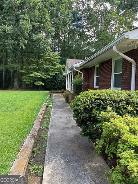 view of side of home with a yard