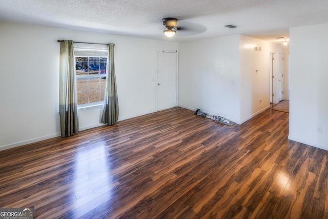 spare room featuring ceiling fan, dark hardwood / wood-style floors, and a textured ceiling