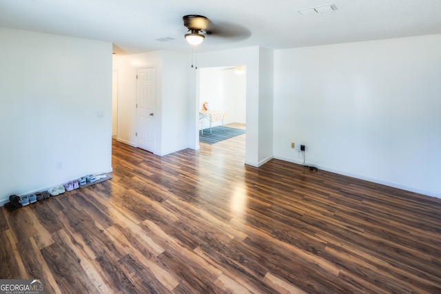 spare room featuring dark wood-type flooring and ceiling fan