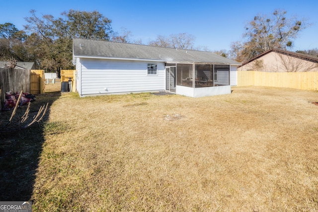 back of house with a sunroom and a yard