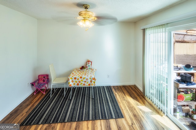 interior space with ceiling fan, hardwood / wood-style floors, and a textured ceiling