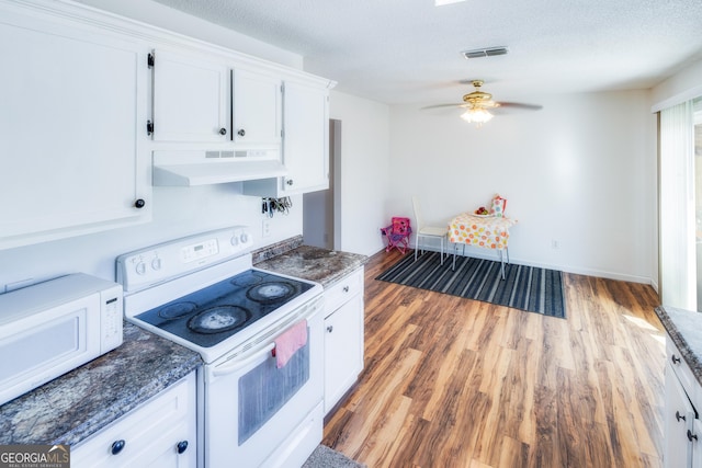 kitchen with a textured ceiling, white cabinets, and white appliances