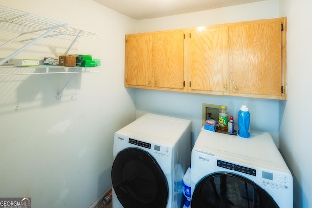 washroom with cabinets and washing machine and clothes dryer