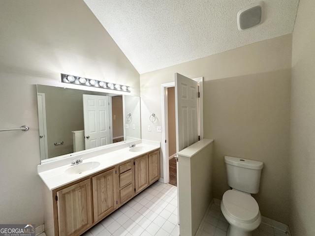 bathroom featuring lofted ceiling, tile patterned flooring, vanity, toilet, and a textured ceiling