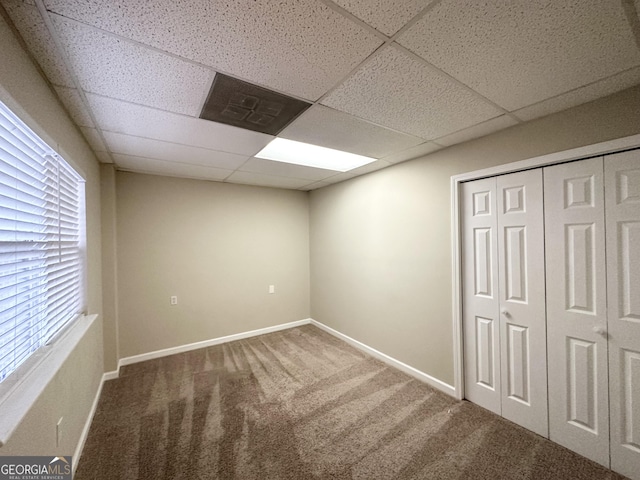 basement featuring carpet and a drop ceiling