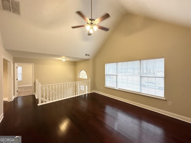 empty room with hardwood / wood-style flooring, ceiling fan, and high vaulted ceiling