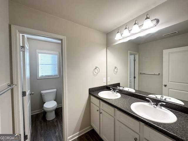 bathroom with wood-type flooring, toilet, and vanity