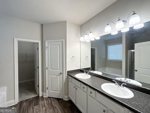 bathroom featuring vanity, wood-type flooring, and separate shower and tub