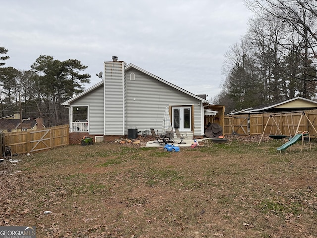 back of property with central AC unit, a lawn, french doors, and a patio area