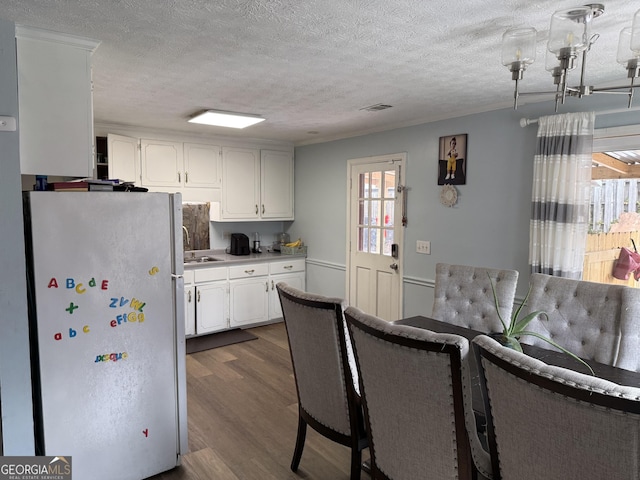 2615 Leeshire Ct, Tucker, GA 30084 - kitchen with freestanding refrigerator, dark wood finished floors, white cabinetry, a textured ceiling, and a sink