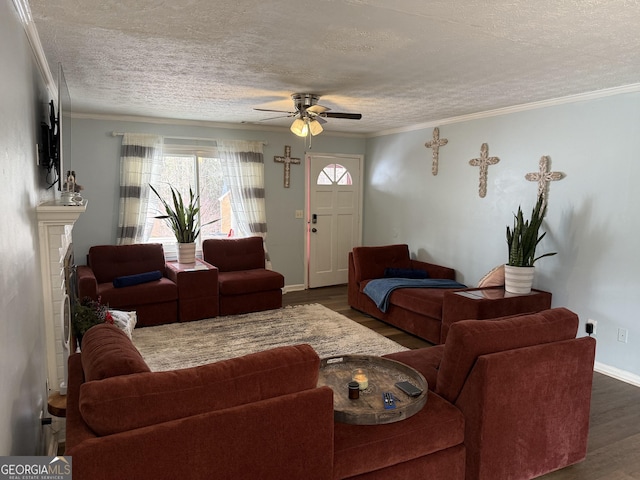 living room with ceiling fan, dark wood-type flooring, ornamental molding, and a textured ceiling