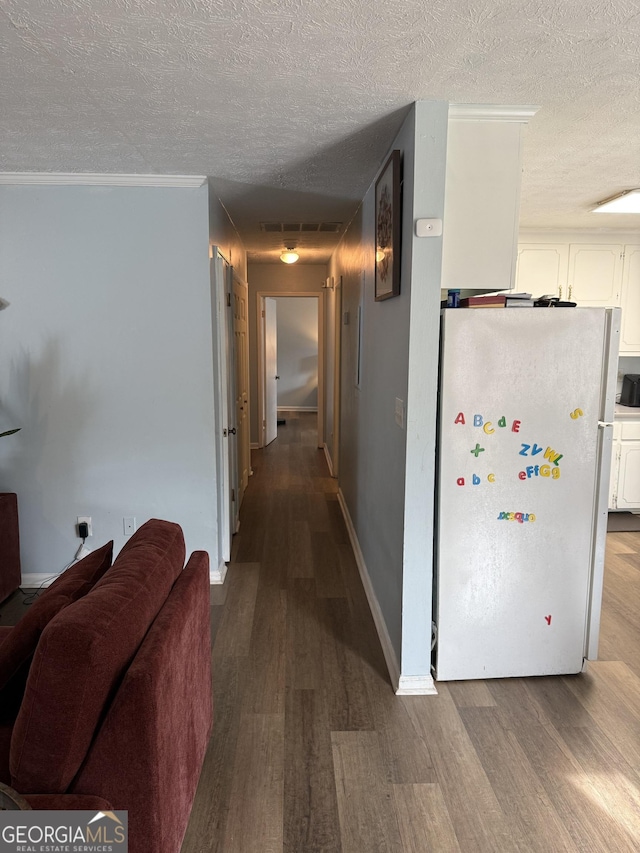 corridor featuring crown molding, hardwood / wood-style floors, and a textured ceiling