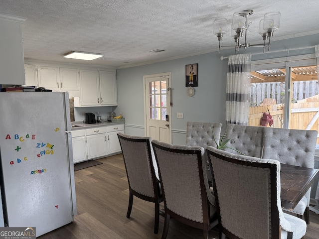 dining area featuring dark wood-type flooring and a textured ceiling