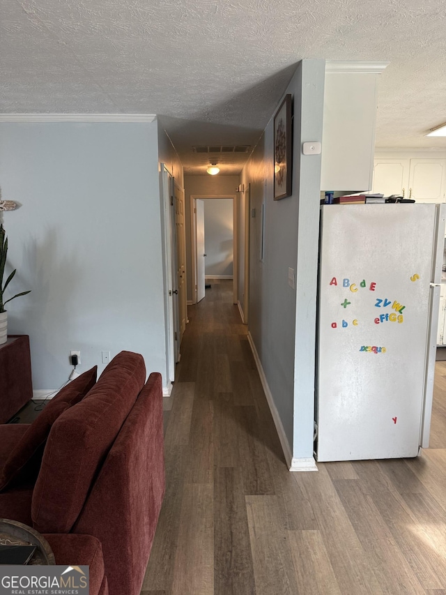 hall featuring crown molding, wood-type flooring, and a textured ceiling