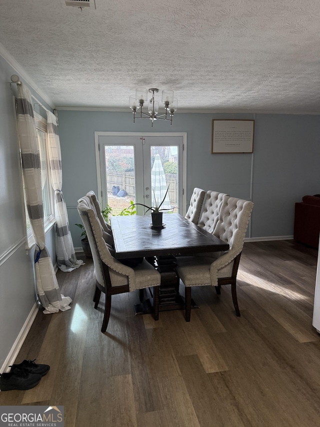 dining area featuring wood-type flooring, a textured ceiling, and french doors