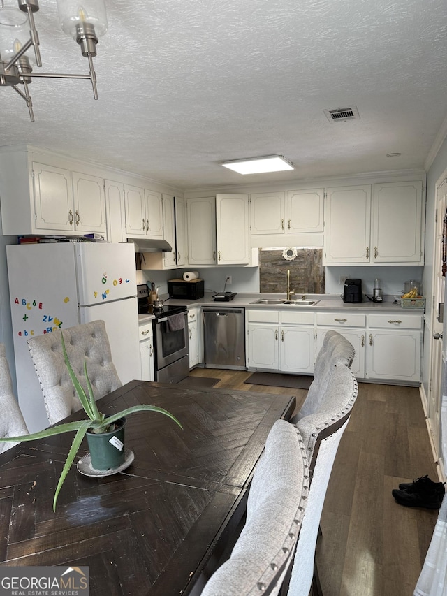 kitchen featuring appliances with stainless steel finishes, sink, white cabinets, and a textured ceiling