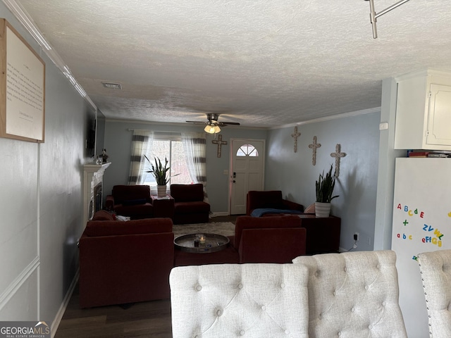 living room featuring hardwood / wood-style floors, ornamental molding, a textured ceiling, and ceiling fan