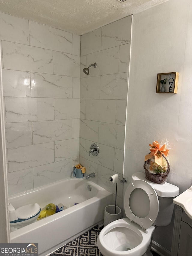 full bathroom with vanity, toilet, tiled shower / bath combo, and a textured ceiling