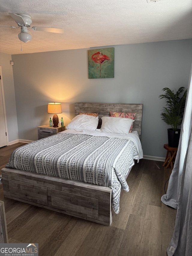 bedroom with dark hardwood / wood-style floors, a textured ceiling, and ceiling fan