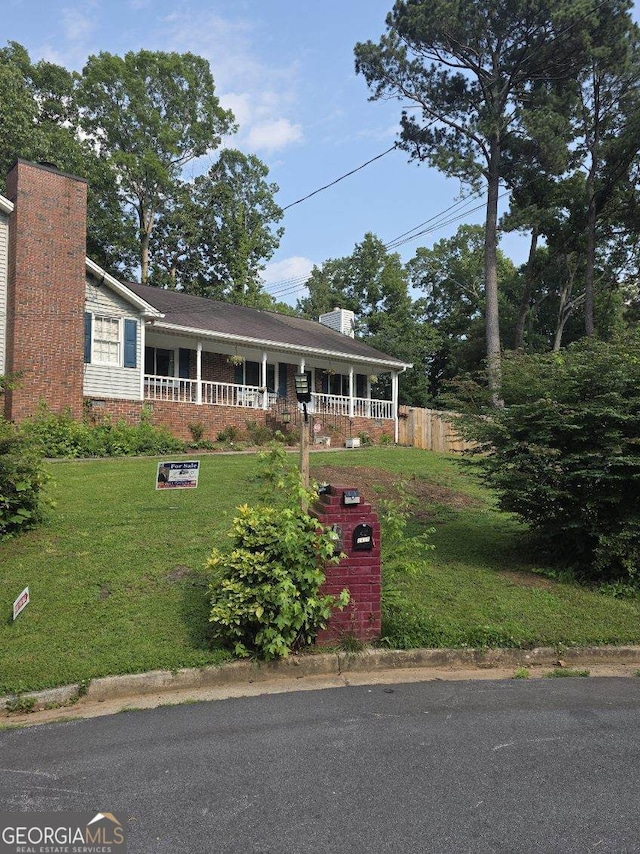 2615 Leeshire Ct, Tucker, GA 30084 - view of front facade featuring a chimney, a front yard, and covered porch