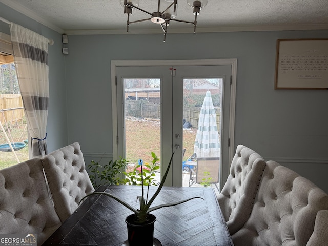 2615 Leeshire Ct, Tucker, GA 30084 - dining area with a textured ceiling, ornamental molding, plenty of natural light, and a chandelier