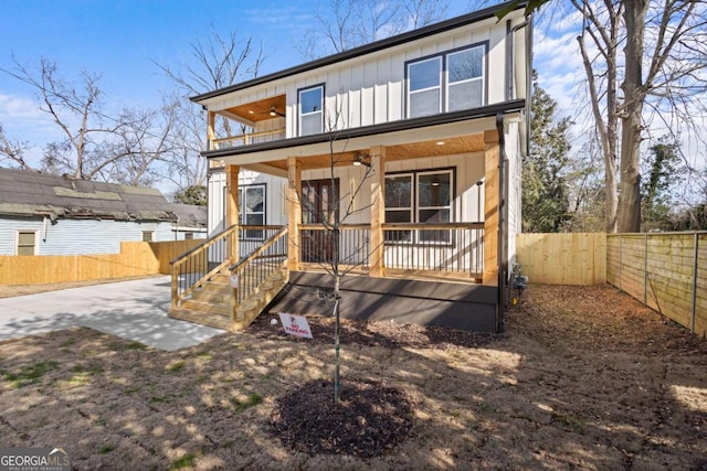 rear view of property with ceiling fan and a porch