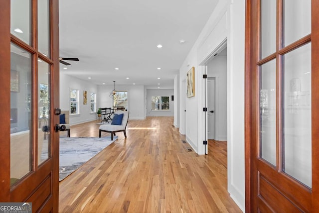 entrance foyer with ceiling fan, light wood-type flooring, and french doors