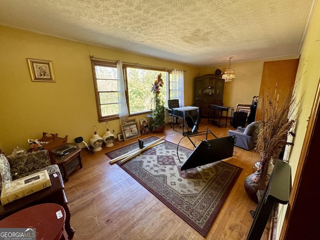 living room with hardwood / wood-style flooring, an inviting chandelier, and a textured ceiling