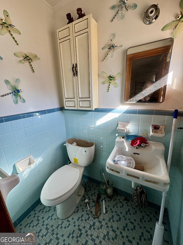 bathroom featuring tile patterned flooring, sink, tile walls, and toilet