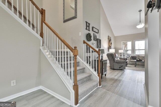 128 Greenview Dr, Newnan, GA 30265 - staircase featuring wood finished floors, a towering ceiling, and baseboards