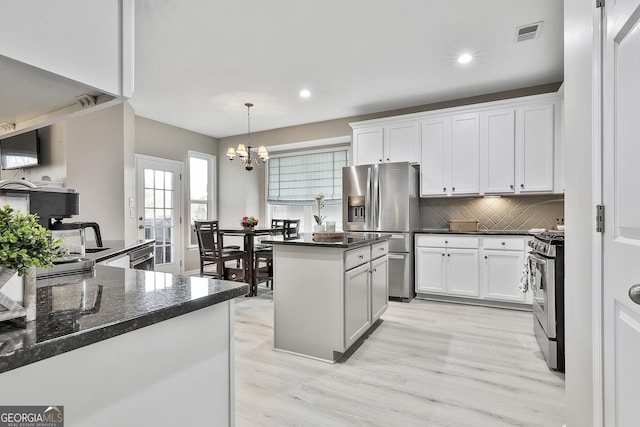 kitchen with pendant lighting, appliances with stainless steel finishes, and white cabinets