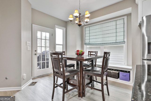 128 Greenview Dr, Newnan, GA 30265 - dining space with light wood-style floors, visible vents, baseboards, and a notable chandelier