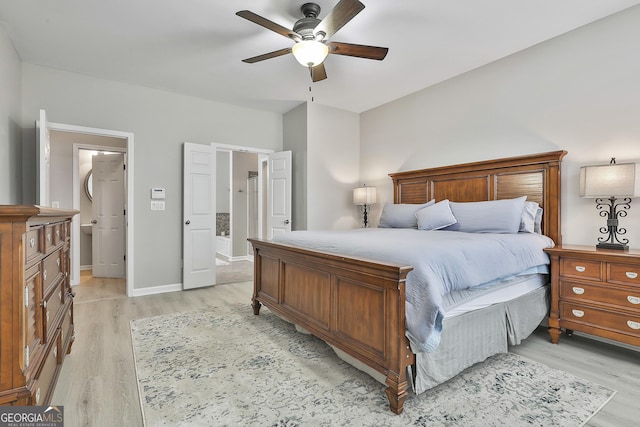 bedroom with ceiling fan, ensuite bath, and light hardwood / wood-style floors