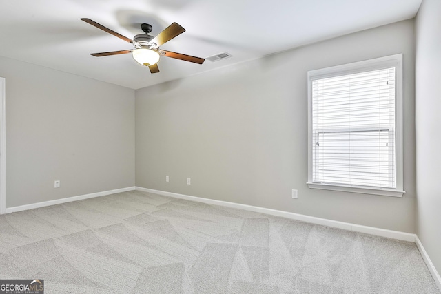 carpeted empty room featuring a wealth of natural light and ceiling fan