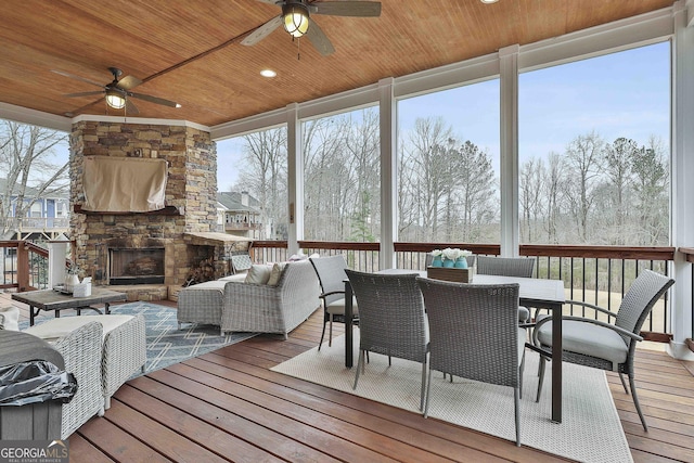 sunroom / solarium with wood ceiling, ceiling fan, and an outdoor stone fireplace