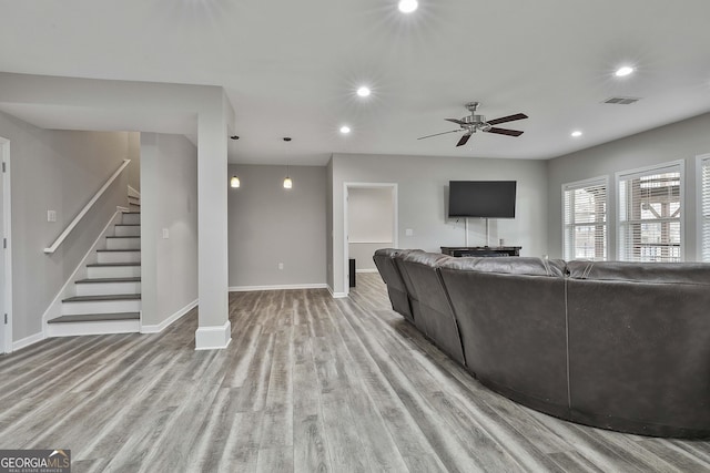 living room with light hardwood / wood-style flooring and ceiling fan