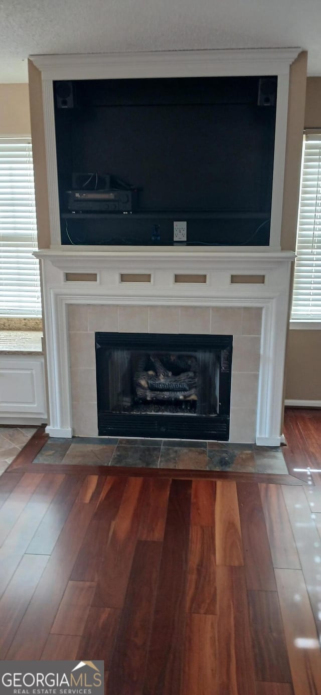 room details with a tiled fireplace and hardwood / wood-style floors