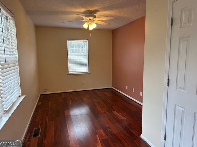 spare room with ceiling fan, dark wood-type flooring, and a textured ceiling