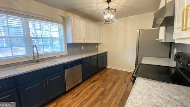 kitchen featuring sink, white cabinetry, tasteful backsplash, wood-type flooring, and stainless steel appliances