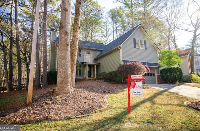 view of property featuring a garage and a front lawn