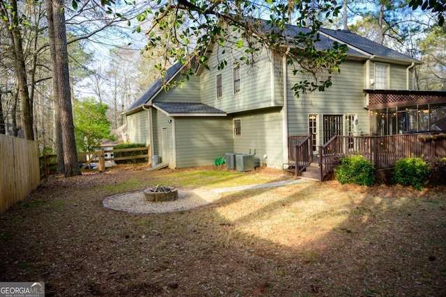 back of house with central AC, a deck, and a fire pit