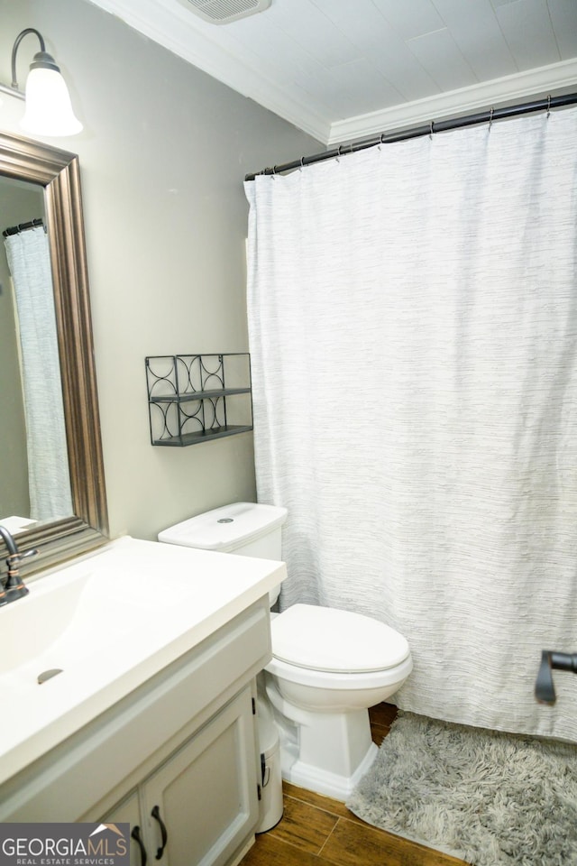 bathroom featuring vanity, hardwood / wood-style floors, crown molding, and toilet